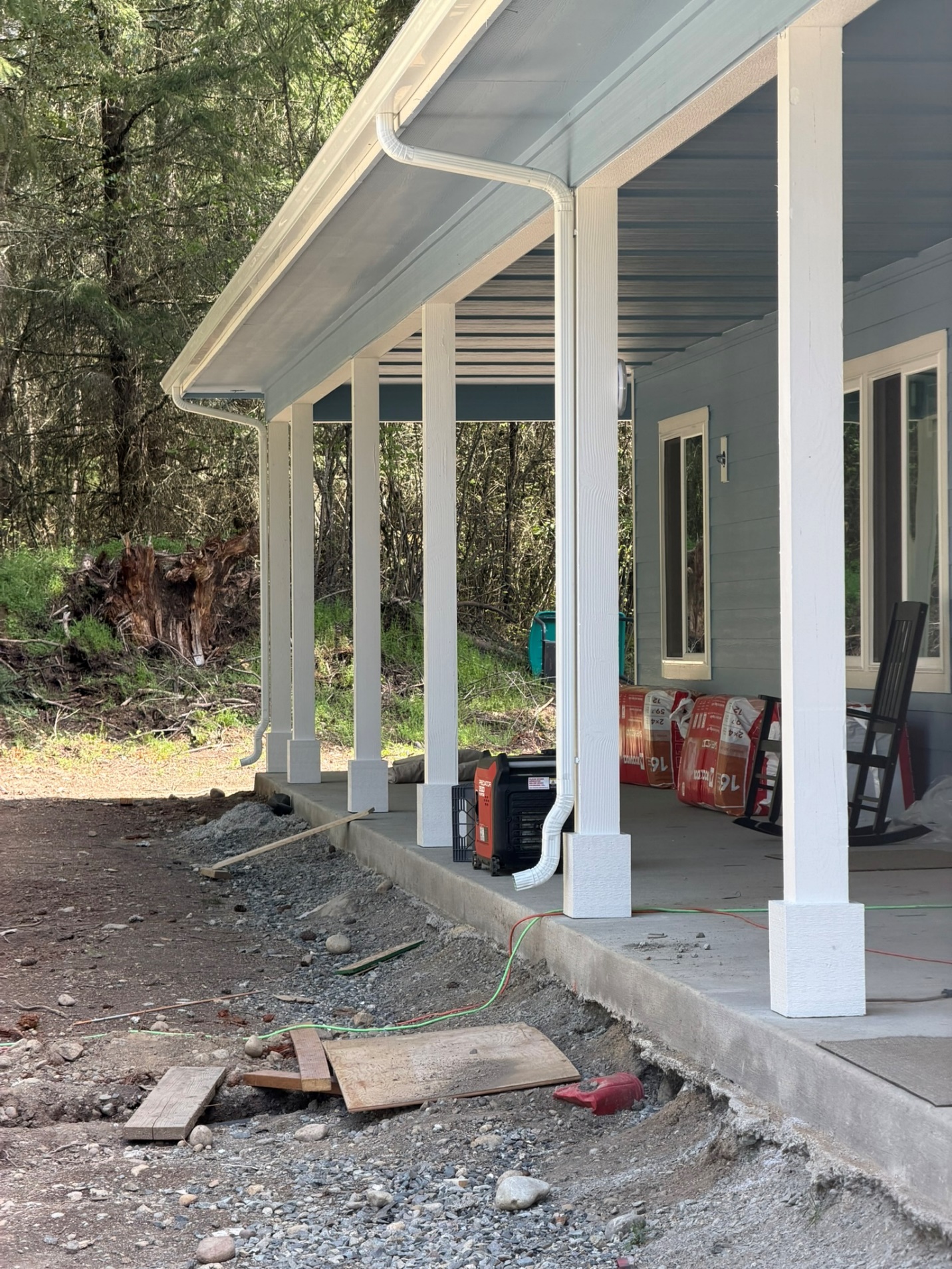 Aluminum seamless gutter and downspout installed along a covered porch roofline