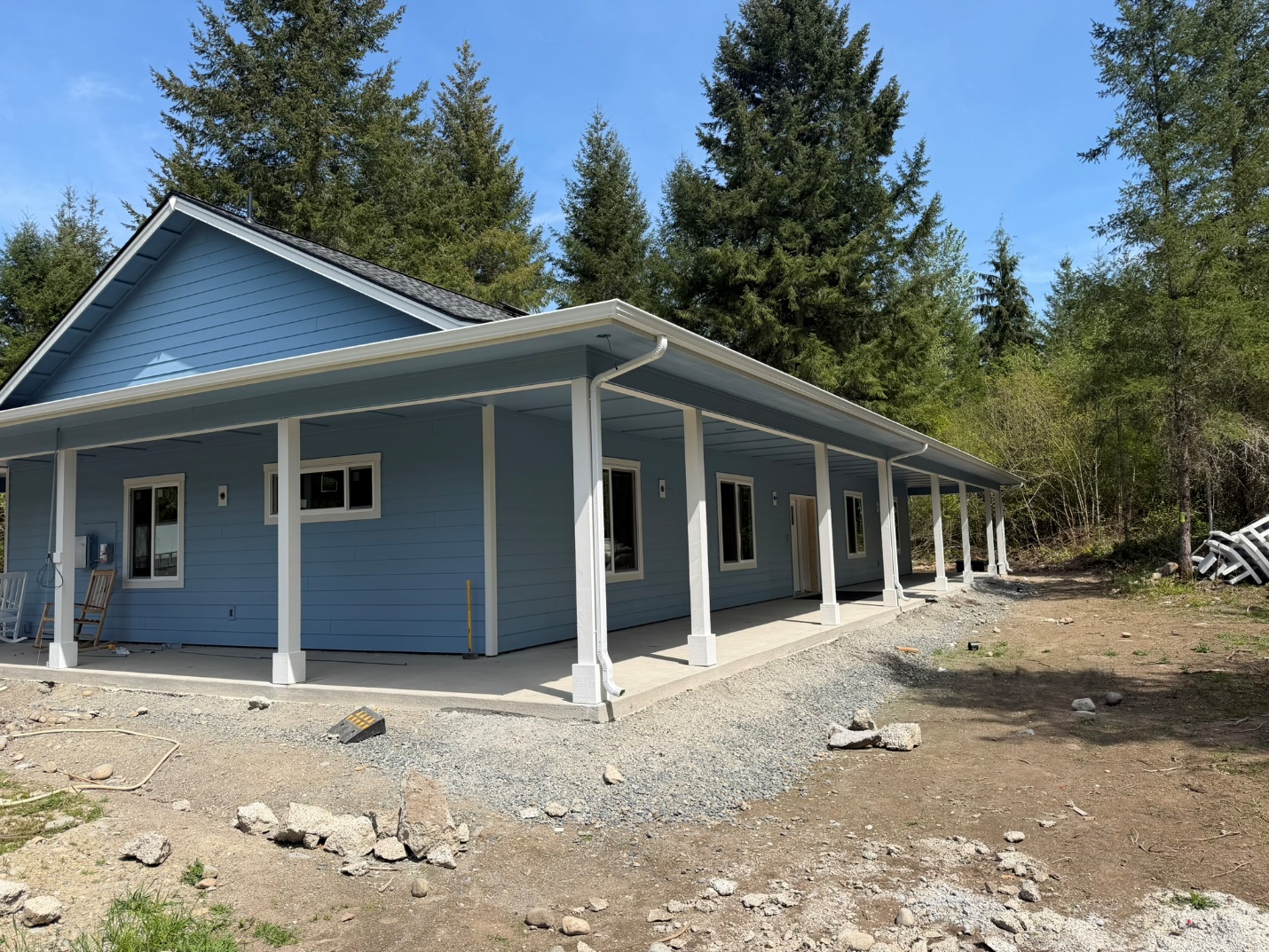 New gutter and downspout installation along a covered porch