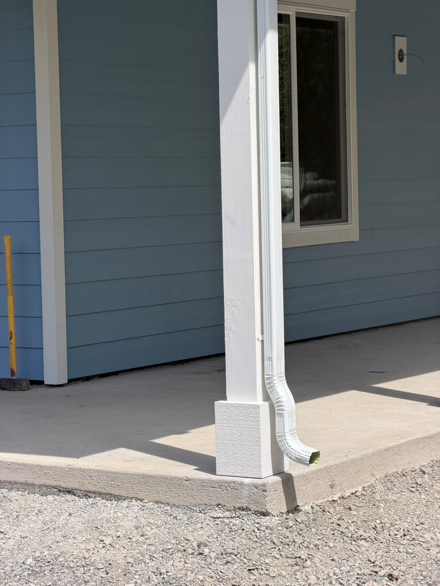 Downspout with a flexible extension directing water away from the base of the home
